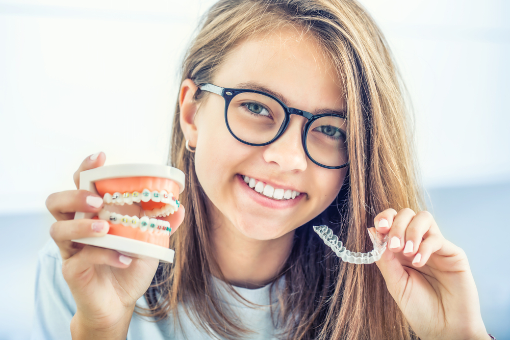 Dental invisible braces or silicone trainer in the hands of a young smiling girl - Emergency Dentist in Lynnwood WA