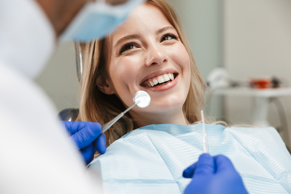 Smiling woman during a dental procedure - Teeth Cleaning in Lynnwood Smiling woman during a dental procedure - Teeth Cleaning in Lynnwood