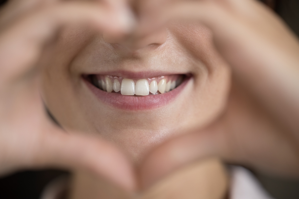 person smiling with a hand heart - teeth whitening person smiling with a hand heart - teeth whitening